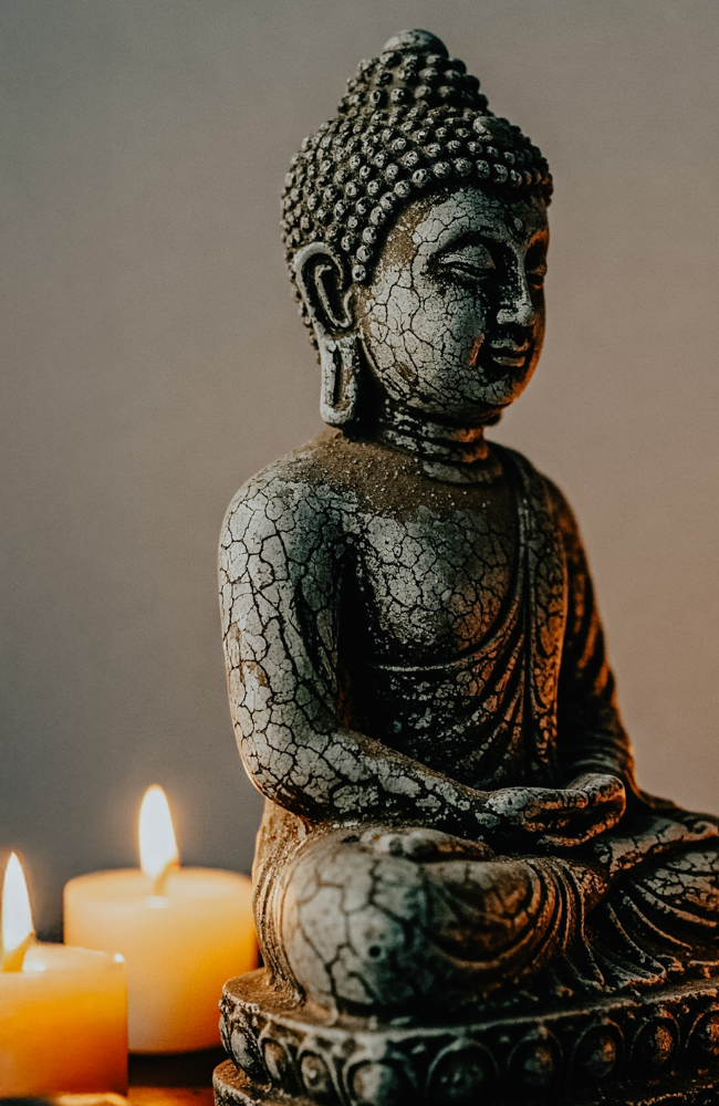 Decorative Buddha meditation statue illuminated by candlelight creating a peaceful mindfulness and meditation space.