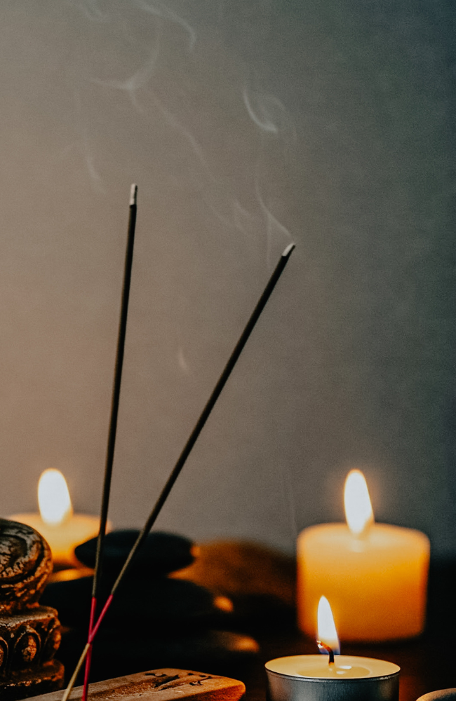 A peaceful Buddha statue surrounded by candles representing mindfulness, meditation, inner peace and spiritual wellbeing. Suitable for meditation blogs, Reiki websites and wellbeing resources.